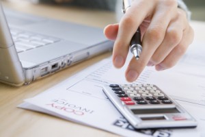 Photo: Financial information, with a calculator and laptop